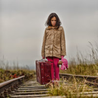 juvenile immigrant walking on railroad tracks