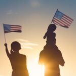Patriotic man, woman, and child waving American flags in the air. Patriotic man, woman, and child waving American flags in the air.