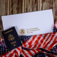USA passport and naturalization certificate of citizenship US flag over wooden background USA passport and naturalization certificate of citizenship US flag over wooden background